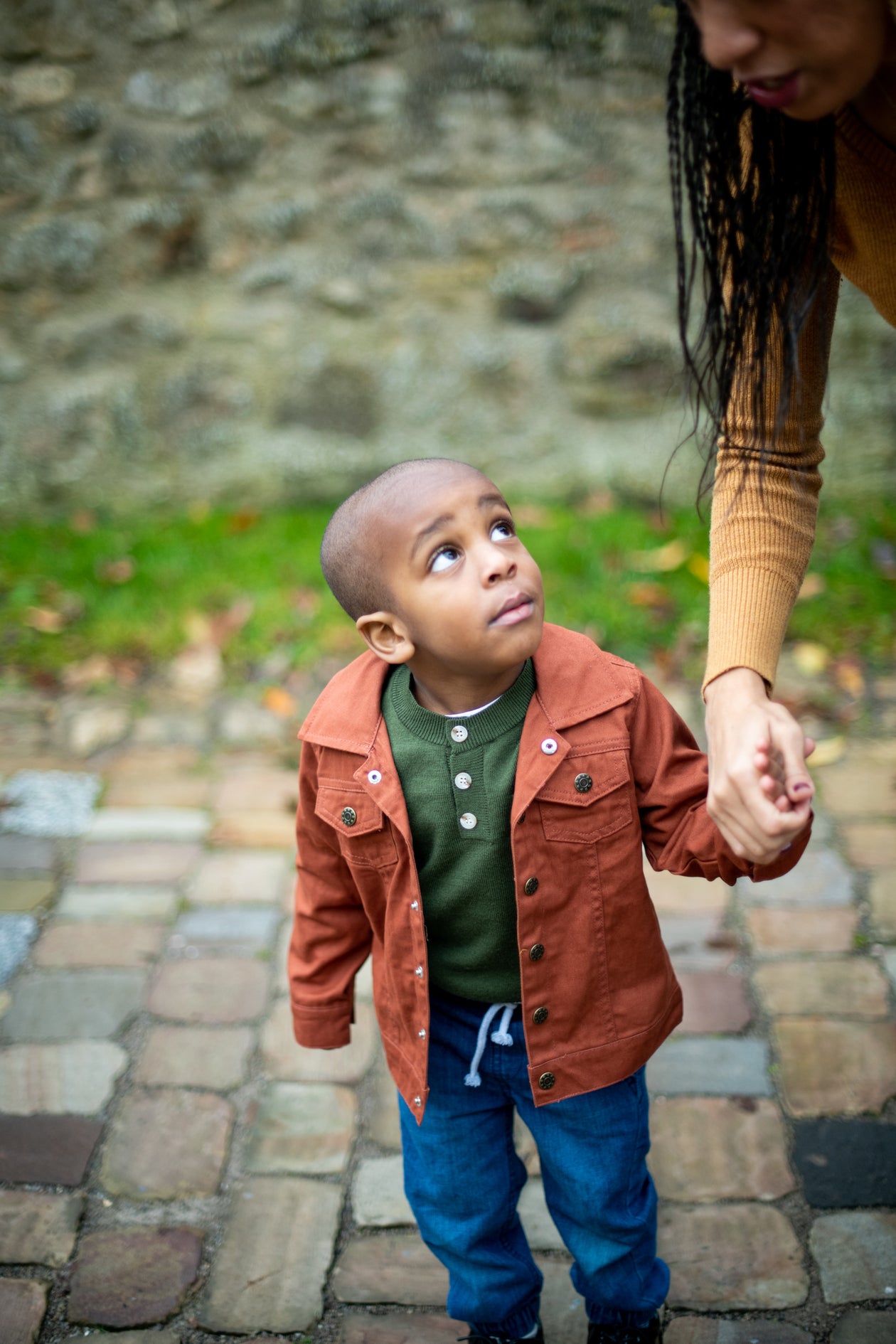 A parent holding her child's hand